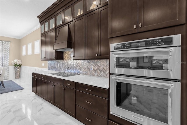 kitchen featuring crown molding, custom range hood, black electric cooktop, stainless steel double oven, and dark brown cabinetry