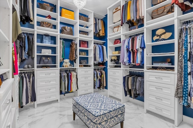 walk in closet featuring a notable chandelier