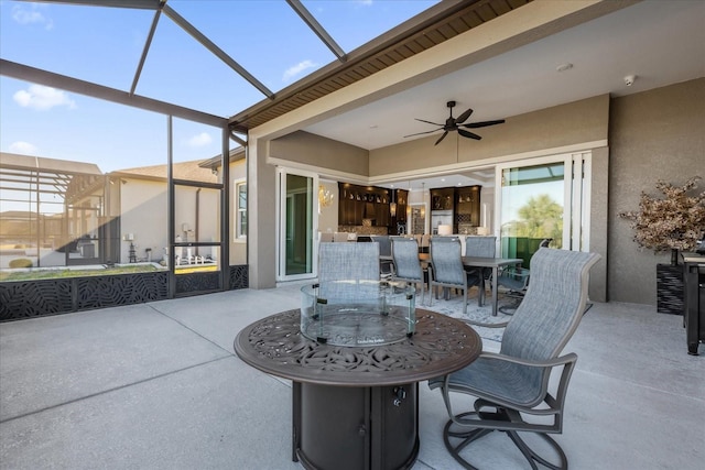 view of patio with ceiling fan and glass enclosure