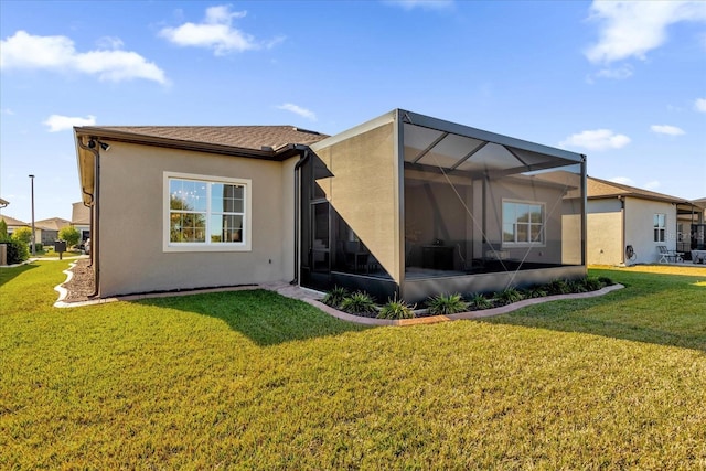 rear view of house featuring a lanai and a lawn