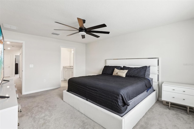 carpeted bedroom with ensuite bathroom and ceiling fan