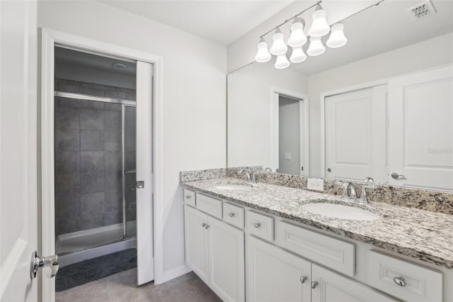 bathroom with an enclosed shower, vanity, and tile patterned floors