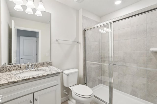 bathroom with vanity, toilet, and a shower with shower door