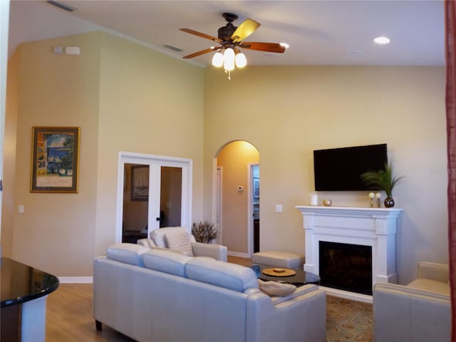 living room with ceiling fan, high vaulted ceiling, and hardwood / wood-style floors