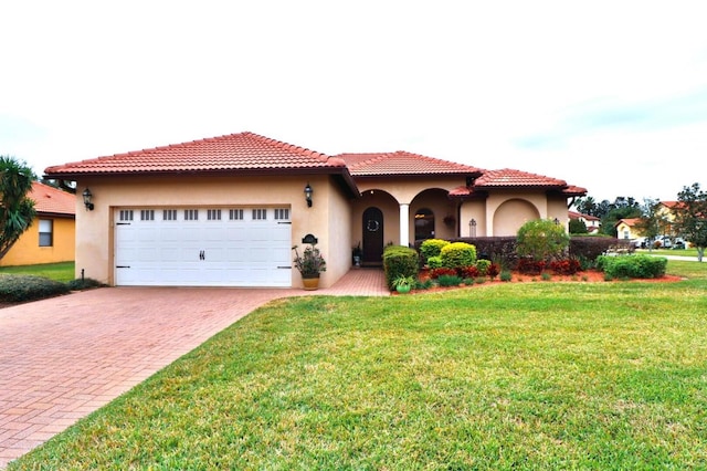 mediterranean / spanish-style home featuring a garage and a front lawn