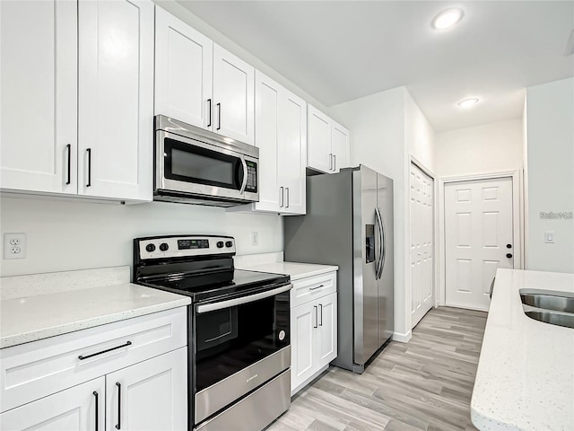 kitchen featuring white cabinets, light stone countertops, and appliances with stainless steel finishes