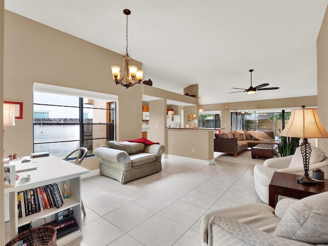 tiled living room with ceiling fan with notable chandelier, plenty of natural light, a water view, and vaulted ceiling