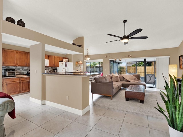 living room featuring ceiling fan, light tile patterned flooring, and lofted ceiling