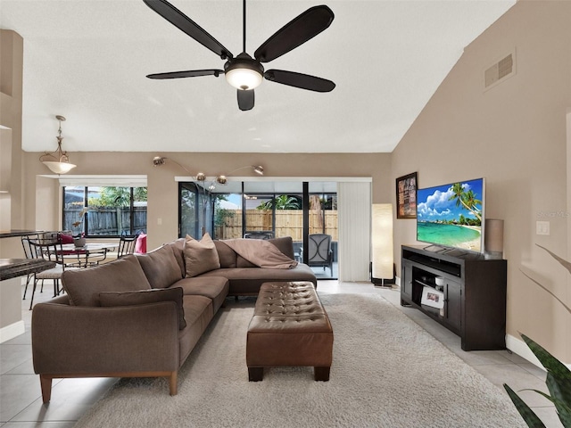 living room with ceiling fan, light tile patterned floors, and vaulted ceiling