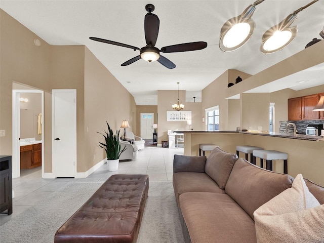 tiled living room featuring ceiling fan with notable chandelier