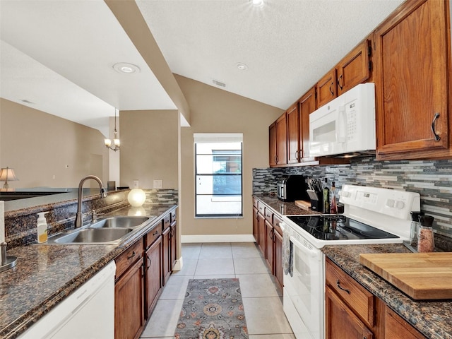 kitchen with white appliances, decorative light fixtures, sink, vaulted ceiling, and light tile patterned floors