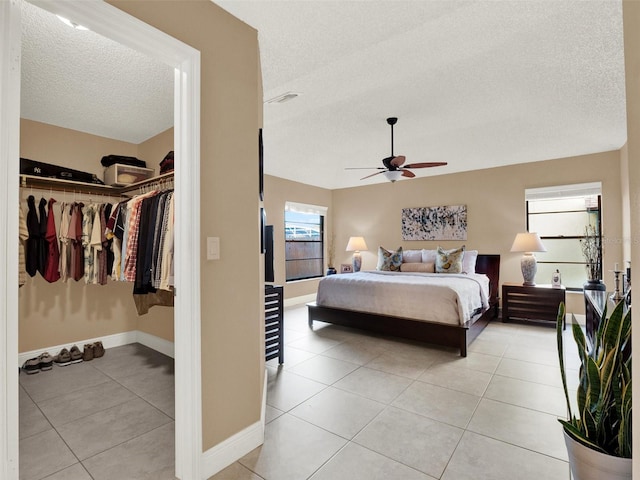 tiled bedroom featuring ceiling fan, a closet, and a textured ceiling