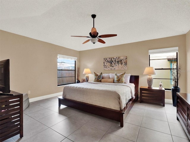 bedroom featuring ceiling fan, a textured ceiling, and light tile patterned floors