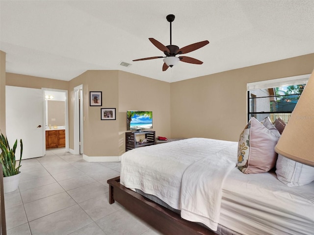 tiled bedroom with ceiling fan and connected bathroom