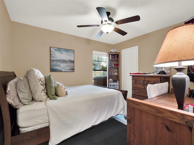 bedroom featuring ceiling fan, carpet, and a textured ceiling