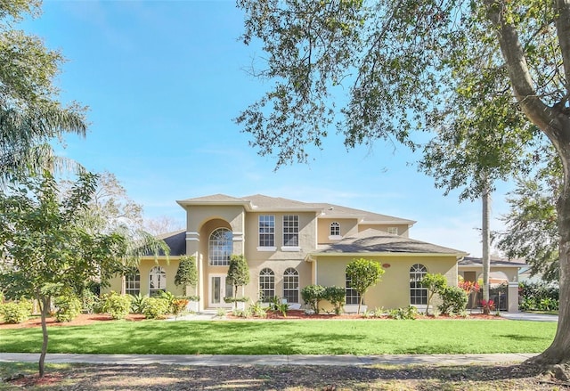 mediterranean / spanish home with a front lawn