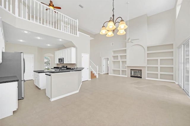 kitchen with white cabinetry, a high ceiling, pendant lighting, built in features, and stainless steel appliances