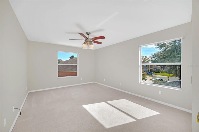 spare room featuring ceiling fan and light carpet