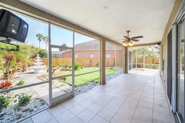 unfurnished sunroom featuring ceiling fan