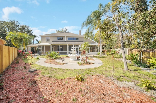 back of house with a sunroom and a yard