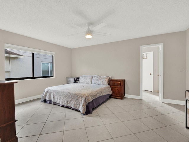 bedroom featuring a textured ceiling, ceiling fan, and light tile patterned flooring