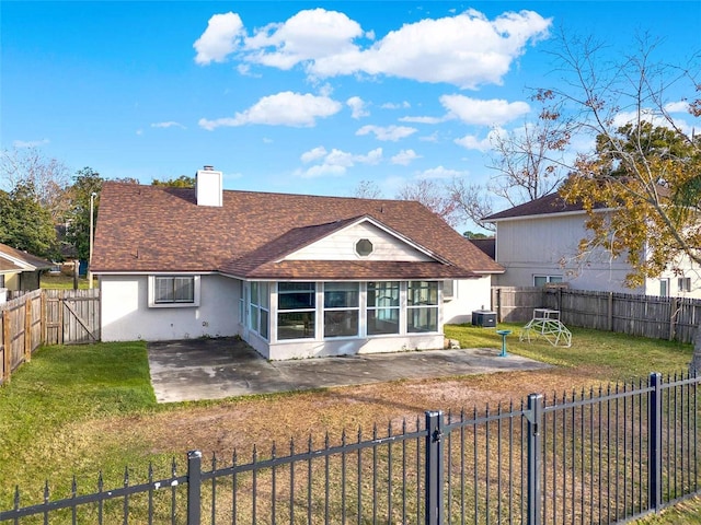 rear view of house featuring a sunroom, a lawn, and a patio