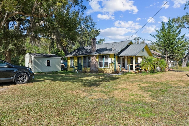 view of front of house with a front yard, a porch, and a shed