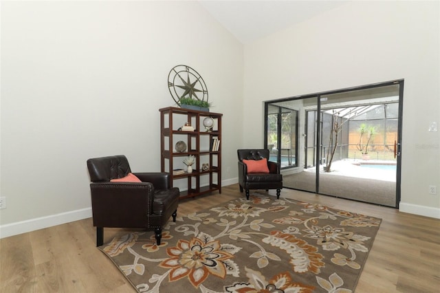 sitting room featuring vaulted ceiling and light hardwood / wood-style flooring