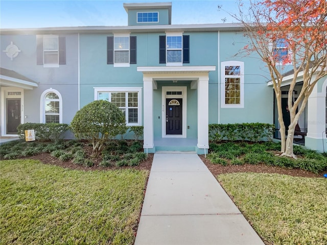 townhome / multi-family property featuring a front yard