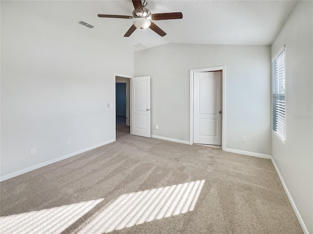 unfurnished bedroom featuring lofted ceiling, light colored carpet, and ceiling fan