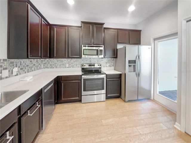 kitchen with dark brown cabinetry, appliances with stainless steel finishes, and tasteful backsplash