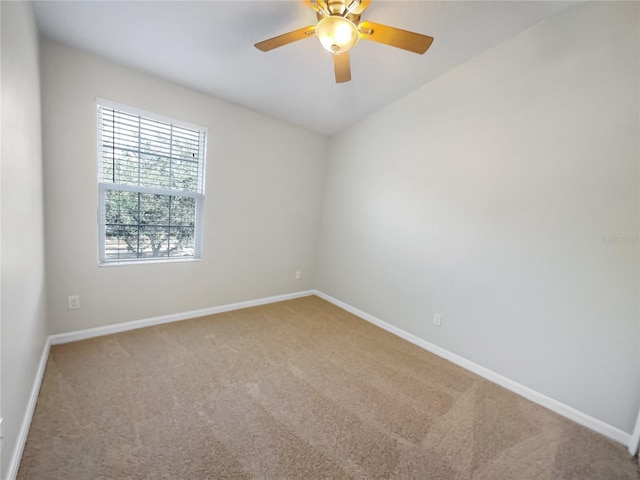 carpeted spare room featuring ceiling fan