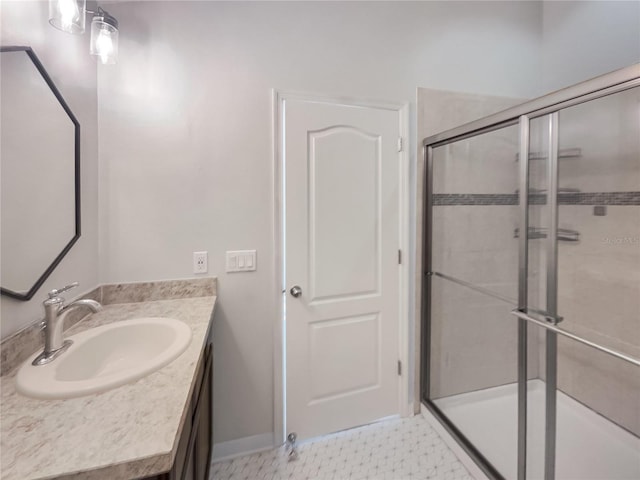 bathroom featuring a shower with shower door and vanity