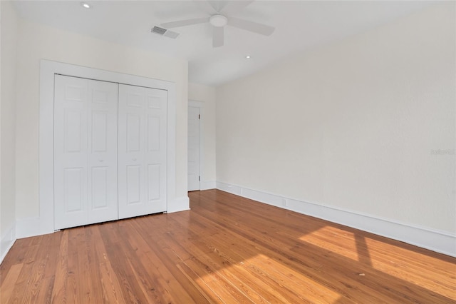 unfurnished bedroom with hardwood / wood-style flooring, a closet, and ceiling fan