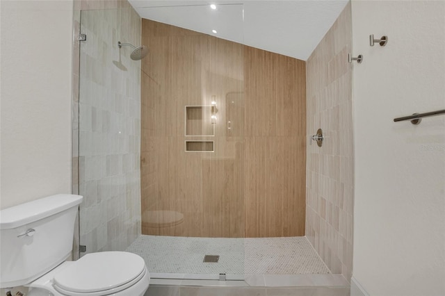 bathroom featuring tile patterned floors, toilet, and tiled shower