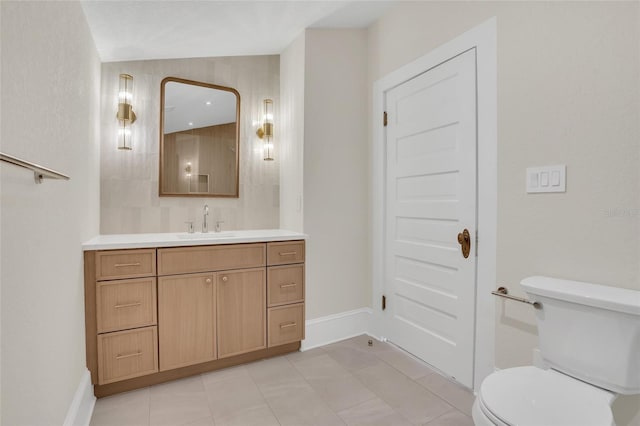 bathroom featuring toilet, vanity, and tile patterned flooring