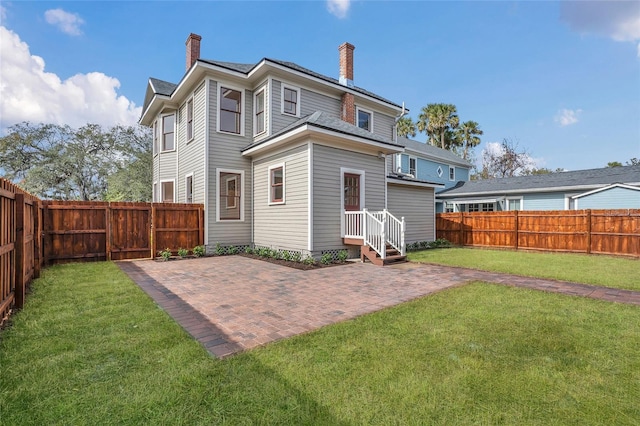 back of property with a yard and a patio