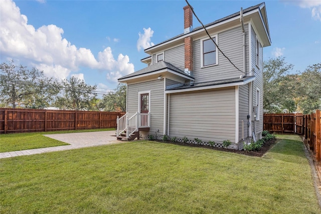 rear view of property featuring a patio and a lawn