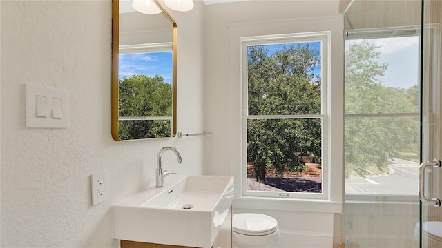 219 Laurel Ave, Sanford, FL 32771 - bathroom featuring vanity, a textured wall, healthy amount of natural light, toilet, and a shower with door