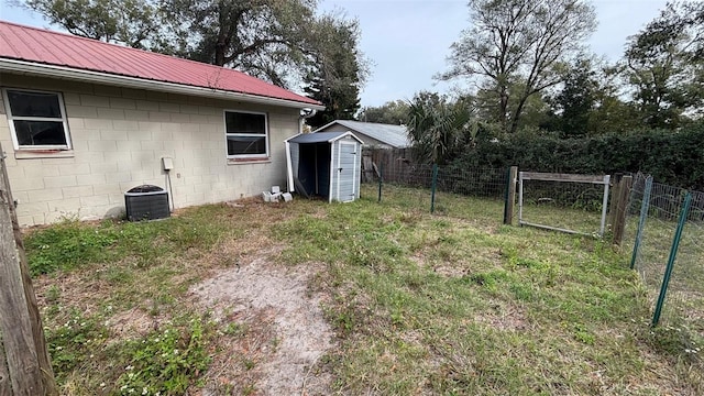 view of yard with central AC unit and a shed