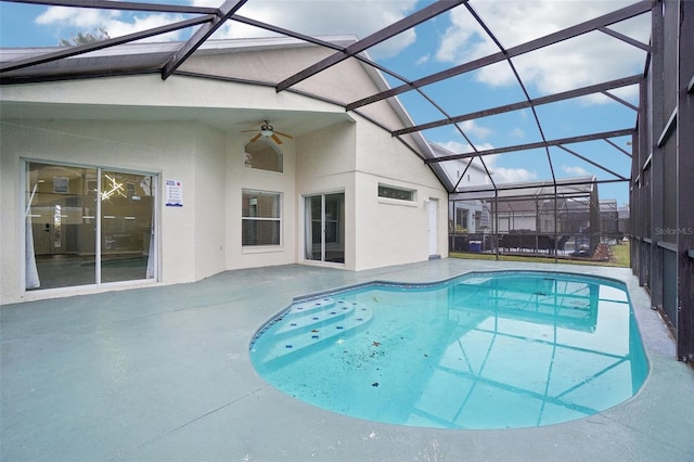 view of swimming pool featuring a lanai and ceiling fan