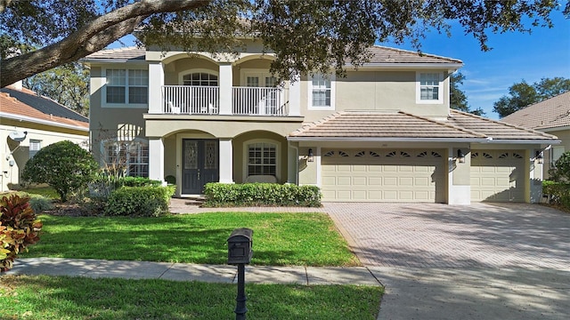 view of front facade with french doors, a balcony, and a front yard