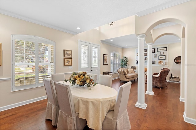 dining room featuring ornamental molding, dark hardwood / wood-style floors, and ornate columns