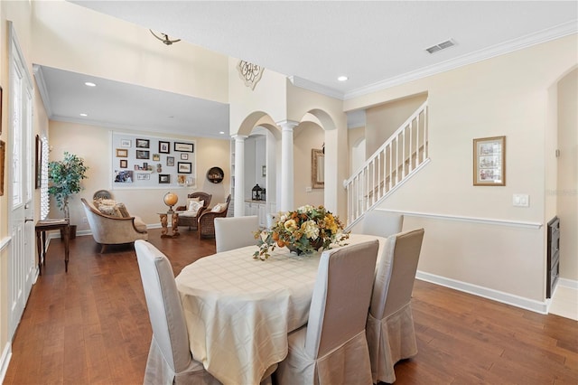 dining room with decorative columns, ornamental molding, and dark hardwood / wood-style flooring