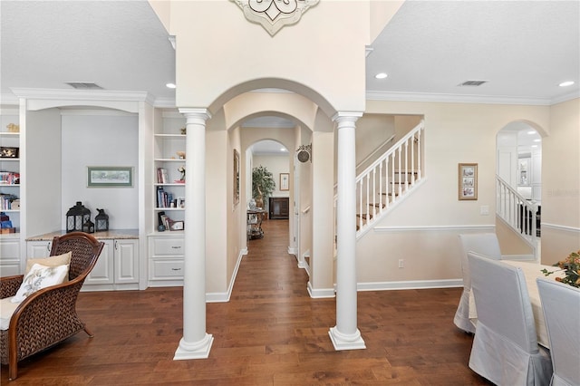 foyer featuring dark wood-type flooring, crown molding, decorative columns, and a textured ceiling