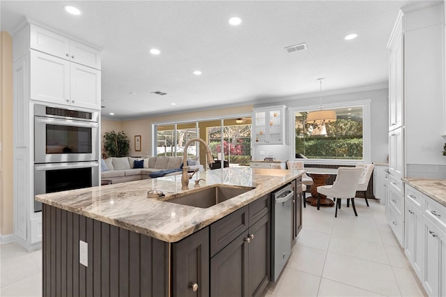 kitchen featuring stainless steel appliances, white cabinetry, sink, and light stone counters