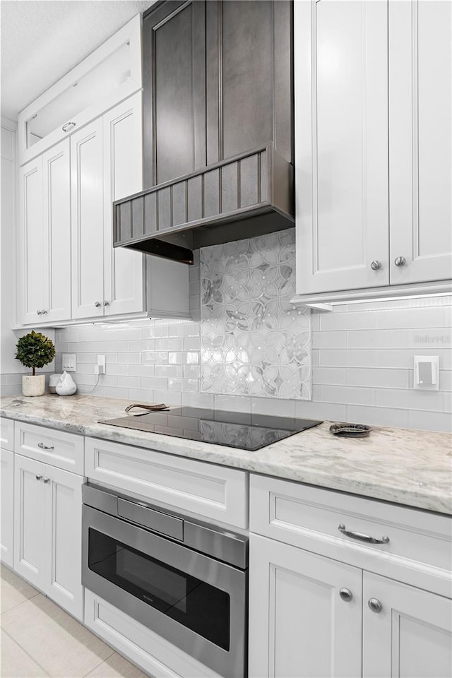 kitchen with white cabinetry, black electric stovetop, and wall oven