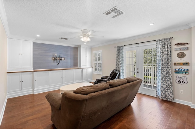 living room with ceiling fan, ornamental molding, a textured ceiling, dark hardwood / wood-style flooring, and french doors