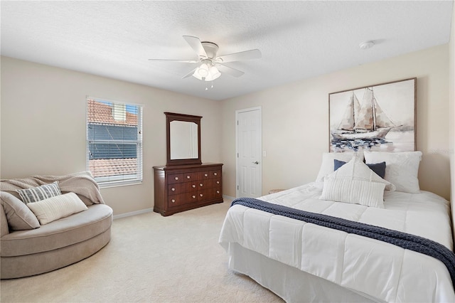 carpeted bedroom featuring ceiling fan and a textured ceiling