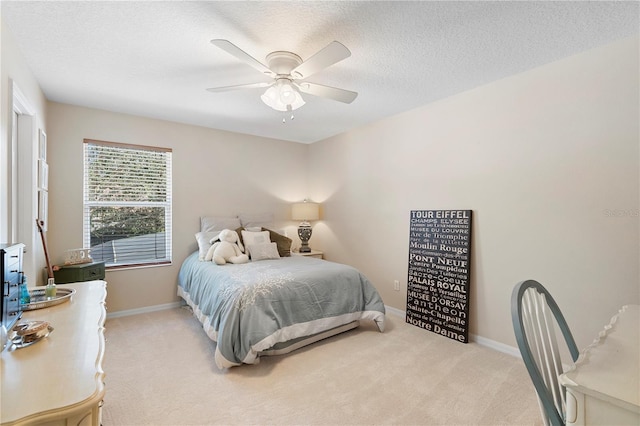 carpeted bedroom featuring ceiling fan and a textured ceiling